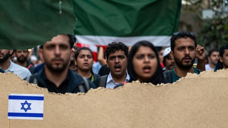Israeli and Somaliland flags with a crowd protesting.