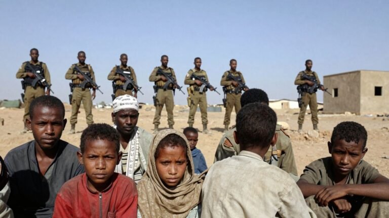 Paramilitary fighters guard displaced survivors in Darfur.