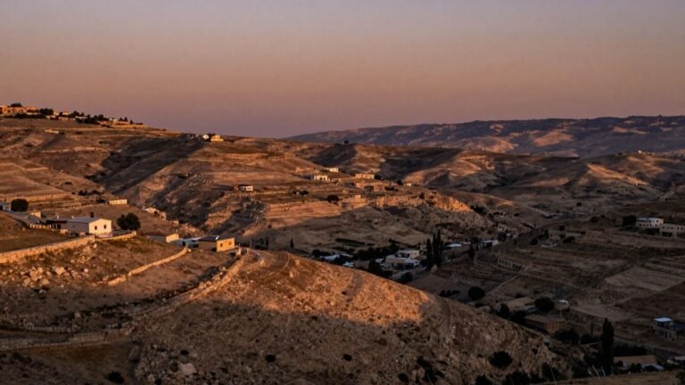 West Bank hills with scattered outposts at sunset.