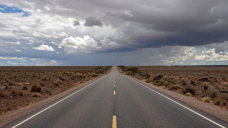 Argentina's economic crossroads with a winding road and changing sky.